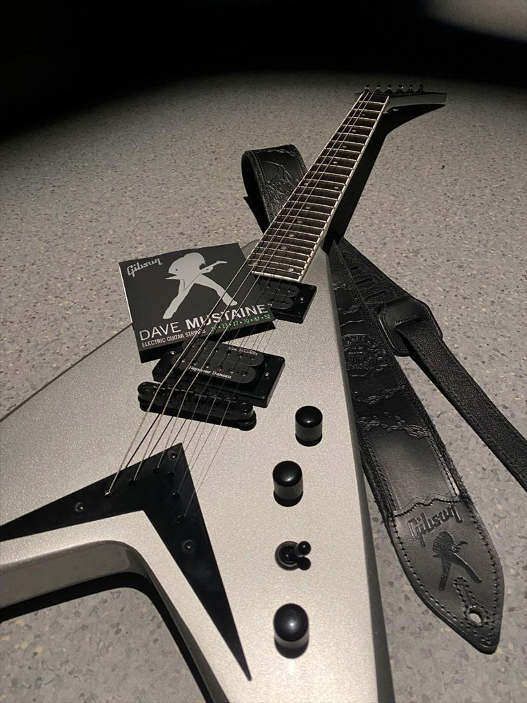 The Dave Mustaine Strap and Strings Collection pictured with the Kramer Dave Mustaine Vanguard in Silver Metallic finish. Credit: Gibson